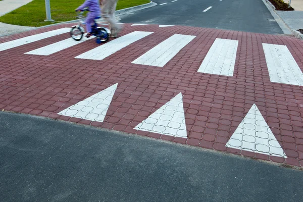 Батько з маленькою дівчинкою на велосипеді, що переходить вулицю — стокове фото