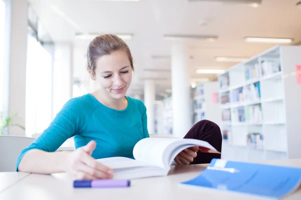 Estudante universitário muito jovem em uma biblioteca — Fotografia de Stock