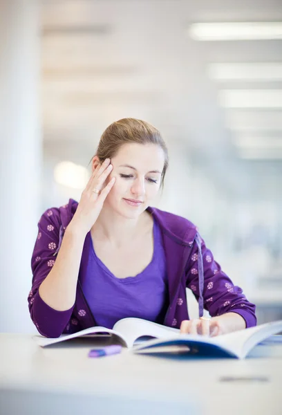 Hübsche junge College-Studentin in einer Bibliothek — Stockfoto