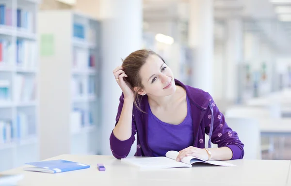 Hübsche junge Studentin in einer Bibliothek (flach dof; Farbe zu — Stockfoto