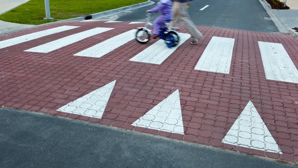 Ο πατέρας με ένα μικρό κορίτσι σε ένα ποδήλατο, διασχίζοντας έναν δρόμο (κίνηση bl — Φωτογραφία Αρχείου