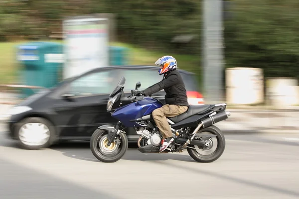 City traffic (panned image, focus on the motorbike) — Stock Photo, Image