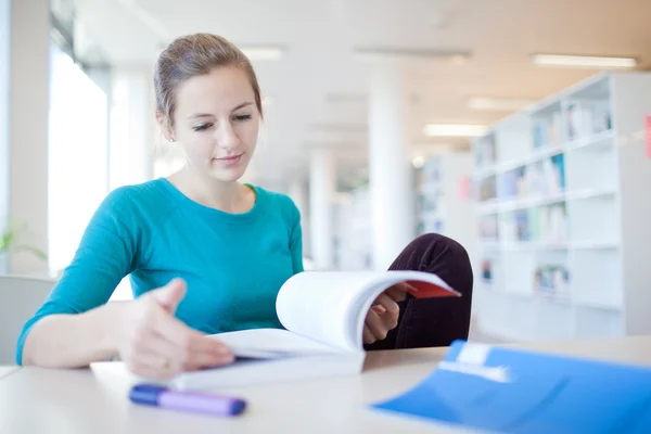 Pretty young college student in a library Royalty Free Stock Photos