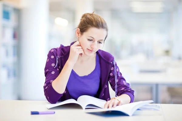 Pretty young college student in a library Royalty Free Stock Images