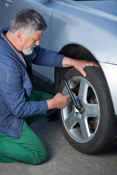 Mechanic changing a wheel of a modern car Royalty Free Stock Images