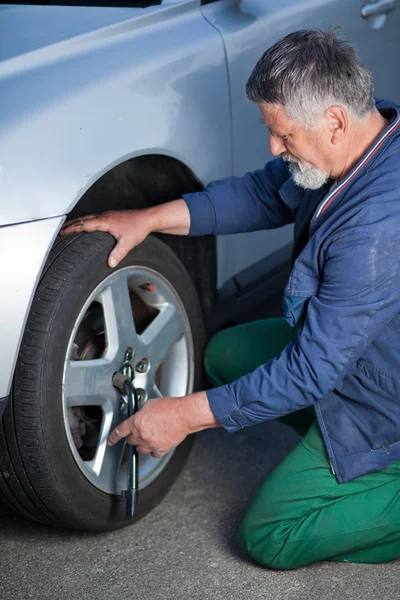 Mechanic changing a wheel of a modern car Royalty Free Stock Photos