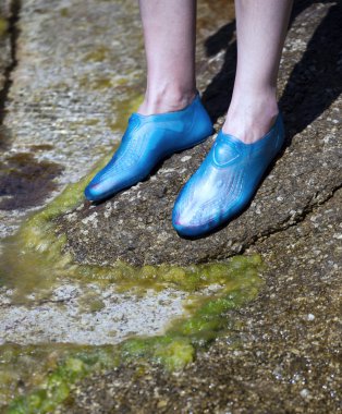 Close-up of a young woman's feet wearing swim shoes clipart