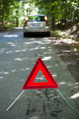 Broken down car with warning triangle clipart