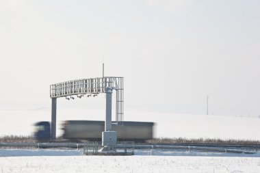 Truck passing trhough a toll gate on a highway clipart