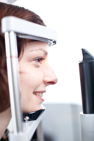 Concepto de optometría: mujer joven y bonita que examina sus ojos — Foto de Stock