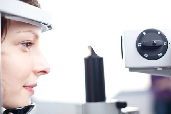 Concepto de optometría: mujer joven y bonita que examina sus ojos — Foto de Stock