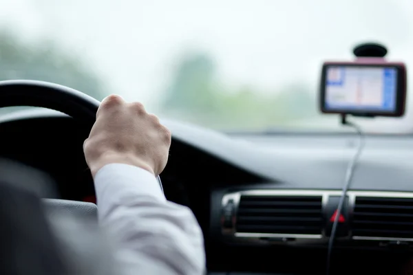 Homem dirigindo um carro com as mãos no volante — Fotografia de Stock