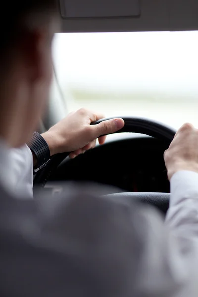 Ο άνθρωπος οδηγεί ένα αυτοκίνητο με τα χέρια του στο τιμόνι — Φωτογραφία Αρχείου
