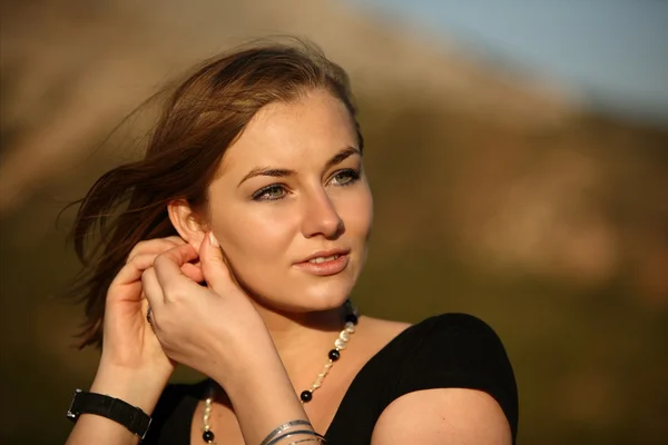 Molto bella giovane donna che fissa il suo orecchino — Foto Stock