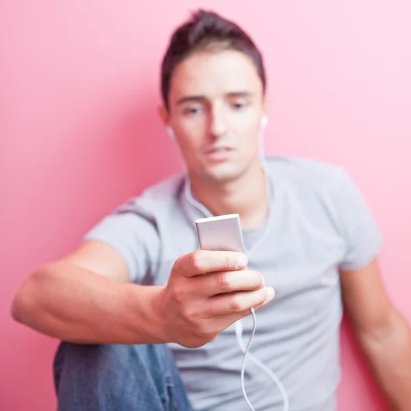 Fiatal jóképű férfi, hallgatni a zenét a hordozható mp3-pl — Stock Fotó