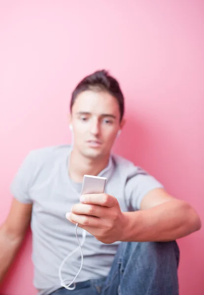 Genç yakışıklı bir adam onun Portable müzik dinlemek mp3 pl — Stok fotoğraf