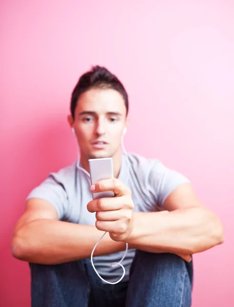 Молодий красивий чоловік слухає музику на своєму портативному mp3 pl — стокове фото