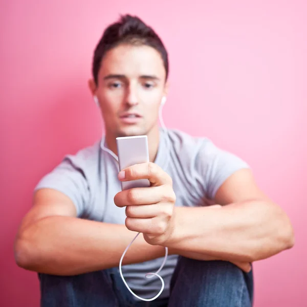 彼の携帯に音楽を聴く若いハンサムな男 mp3 pl — ストック写真
