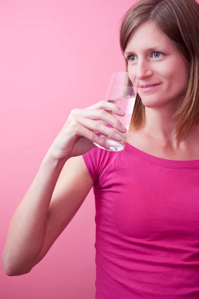Красивая молодая женщина пьет свежую воду из стакана (цвет тонны — стоковое фото