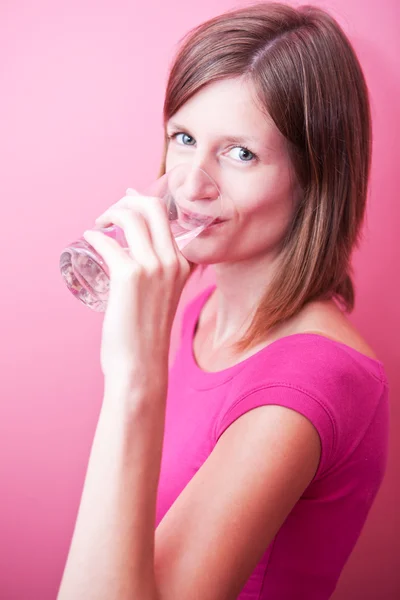Красивая молодая женщина пьет свежую воду из стакана (цвет тонны — стоковое фото