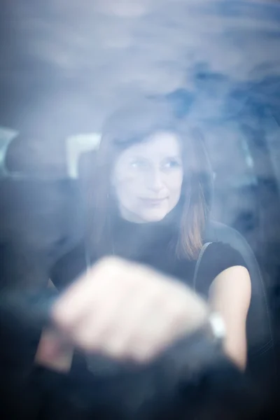 Красивая молодая женщина за рулем своей новой машины (простреленная сквозь ветровое стекло) — стоковое фото