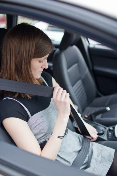 Road safety concept - Pretty young woman fastening her seat belt — Stock Photo, Image