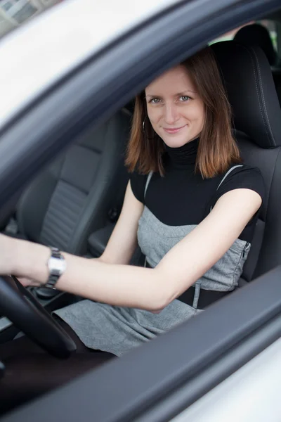 Bella giovane donna alla guida della sua nuova auto (DOF superficiale; colore tonica — Foto Stock