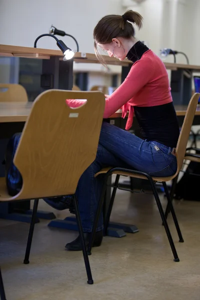 Jolie étudiante dans une bibliothèque universitaire — Photo