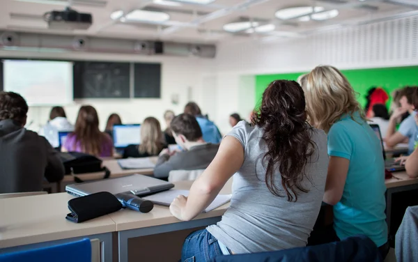 Jovem muito feminino estudante universitário sentado em uma sala de aula — Fotografia de Stock