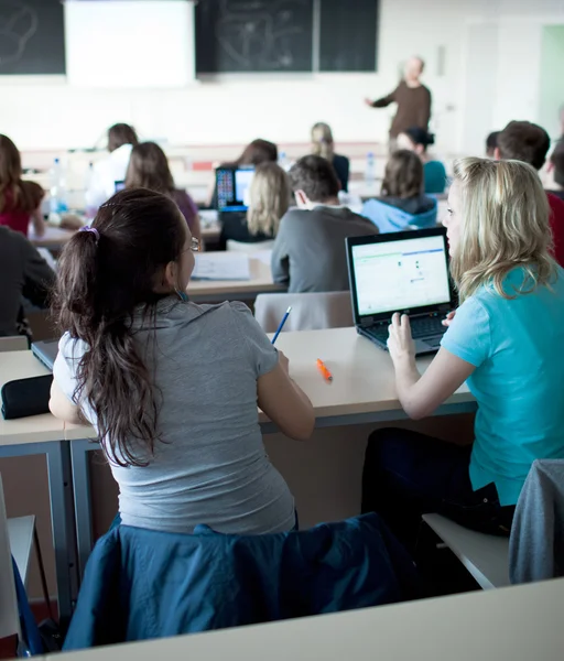 Junge hübsche College-Studentin sitzt in einem Klassenzimmer — Stockfoto