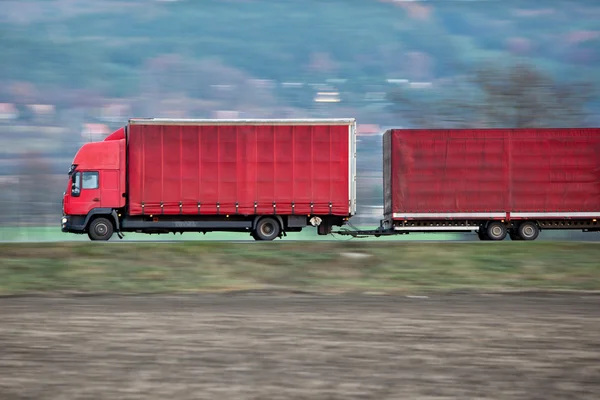 Röd camion/lastbil går snabbt på en väg — Stockfoto