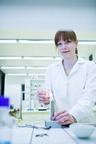 Joven y bonita investigadora encendiendo un quemador en un laboratorio —  Fotos de Stock