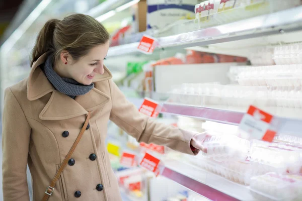 Mujer bastante joven comprando comestibles en un supermercado — Foto de Stock