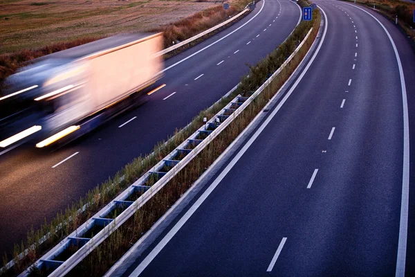 Tráfico por carretera - camión borroso en movimiento en una carretera —  Fotos de Stock