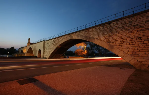 Bilar går snabbt under en vacker gotisk bro — Stockfoto