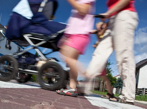 Mutter mit kleinen Kindern und Kinderwagen überquert Straße — Stockfoto