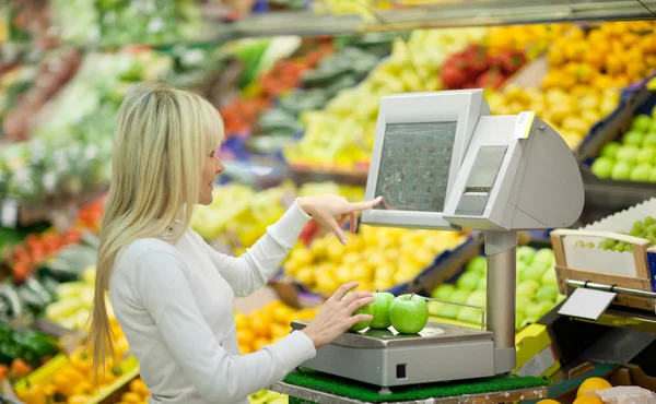 Mooie jonge vrouw winkelen voor groenten en fruit — Stockfoto