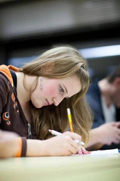 Hezká žena vysokoškolský student sedí zkoušky v učebně — Stock fotografie