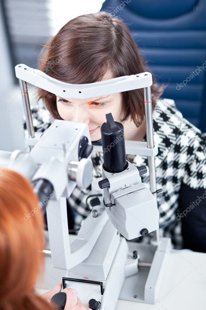 Optometry concept - pretty young woman having her eyes examined
