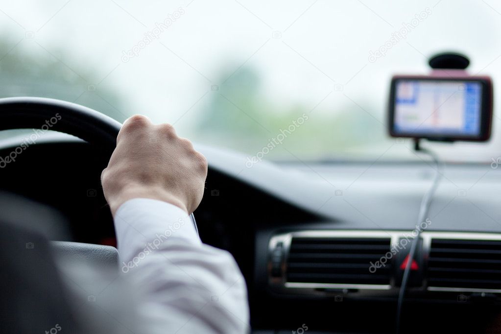 Man driving a car with his hands on the steering wheel