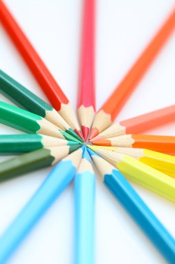 Color pencils in arrange in color wheel colors on white backgrou clipart