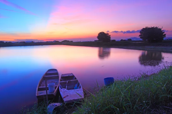 日没時に池に沿って分離ボート — ストック写真