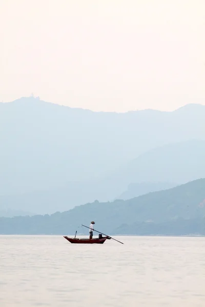 Pescador sobre o oceano e entre as cordilheiras da montanha — Fotografia de Stock
