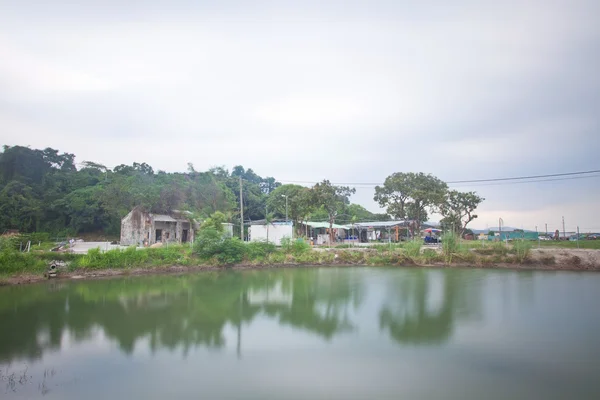 Китайские дома и сад с прудом снаружи — стоковое фото