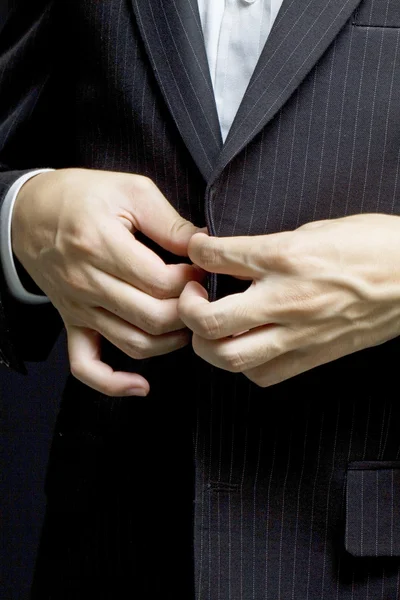 Obchodní muž uklidit svůj oblek tlačítko — Stock fotografie