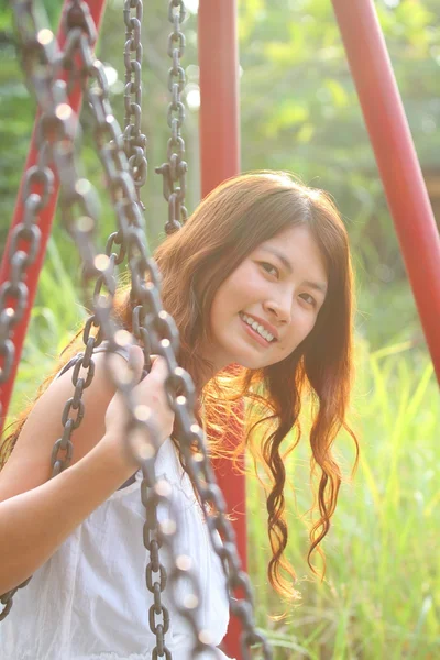 Una hermosa y alegre chica asiática jugando swing —  Fotos de Stock