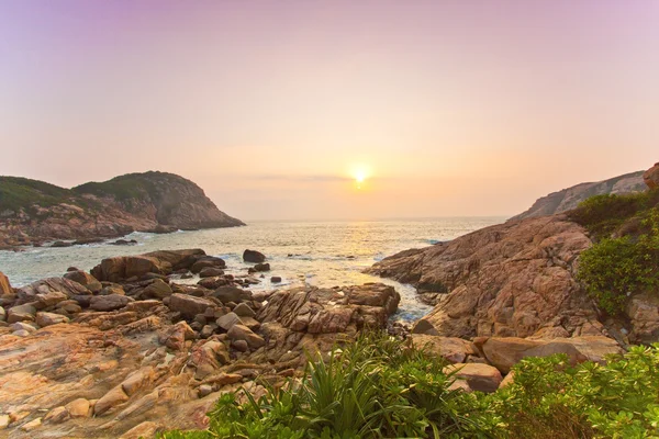 Mořské kameny podél pobřeží za východu slunce — Stock fotografie
