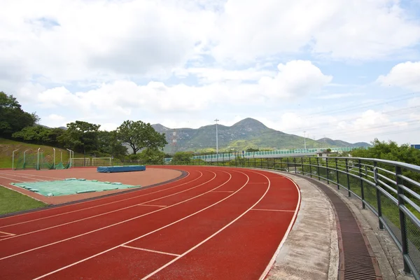 Estádio de esportes com pista de corrida durante o dia — Fotografia de Stock