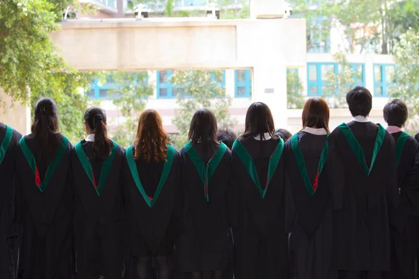 Rücken von Universitätsabsolventen mit ihren Kleidern — Stockfoto