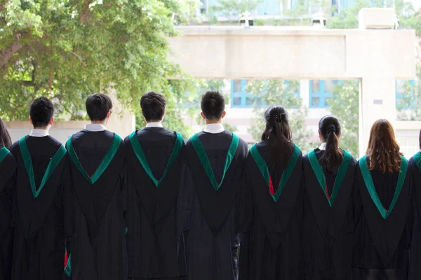Rücken von Universitätsabsolventen mit ihren Kleidern — Stockfoto